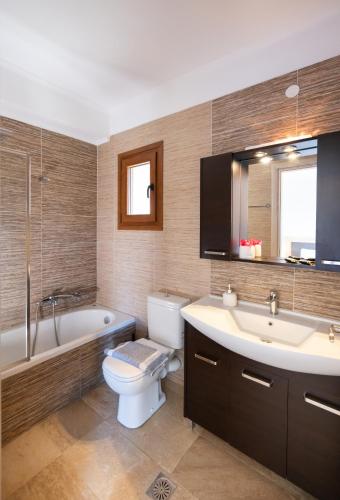 a bathroom with a toilet and a tub and a sink at 180 Mansion in Mikros Gialos