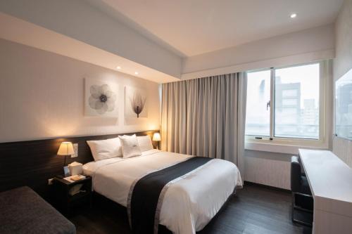 台北的住宿－尚印旅店，酒店客房设有床和窗户。