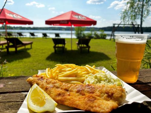 um prato de peixe e batatas fritas e um copo de cerveja em Dolina Sarenek em Sejny