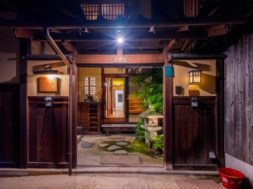 an open door to a garden at night at 清水小筑 清水寺へ徒歩3分 最寄り駅五条坂 最大16人宿泊 in Kyoto
