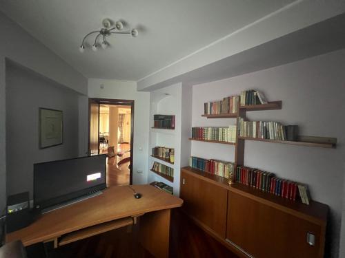 a living room with a tv and a book shelf at Wine Cellar Villa with Beautiful Garden in Sinaia - Busteni in Poiana Ţapului