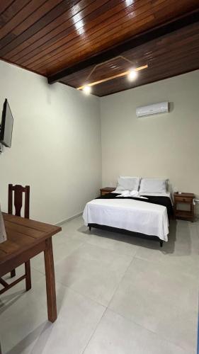 a bedroom with a white bed and a wooden ceiling at Pousada Emerências dos Búzios in Armacao dos Buzios