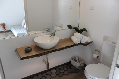 a bathroom with a sink and a toilet and a mirror at Aqua Sea House in Madalena do Mar