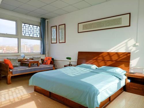 a bedroom with a bed and a chair and windows at 南金民宿 in Qinhuangdao
