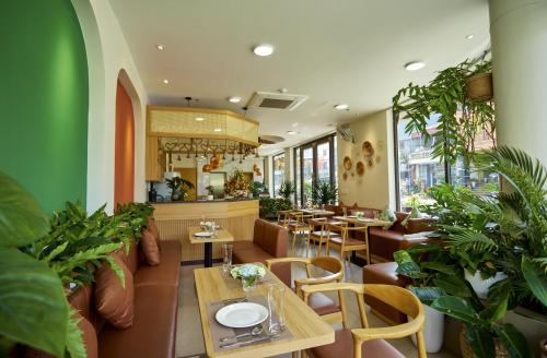 ein Restaurant mit Tischen, Stühlen und Pflanzen in der Unterkunft Tropical Paradise Sapa Hotel & Coffee in Sa Pa