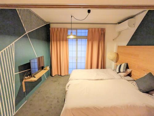 金澤的住宿－Guest Room Tiie，一间卧室配有一张床和一台电视