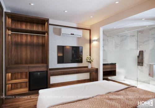 a bedroom with a large bed and a flat screen tv at The Cosy Inn Hanoi in Hanoi