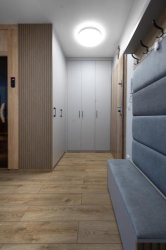 an empty hallway with white doors and a bench at Apartamenty Cicha - bezpłatny parking in Krynica Zdrój