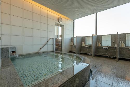a bathroom with a tub with water in it at Hotel Okura Fukuoka in Fukuoka