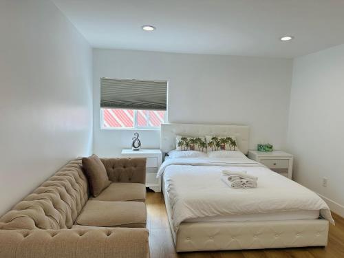 a bedroom with a large bed and a couch at Stylish Retreat Private Room 2 in Los Angeles