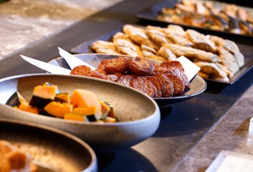 a table with bowls of food and other food items at Hotel Okura Fukuoka in Fukuoka