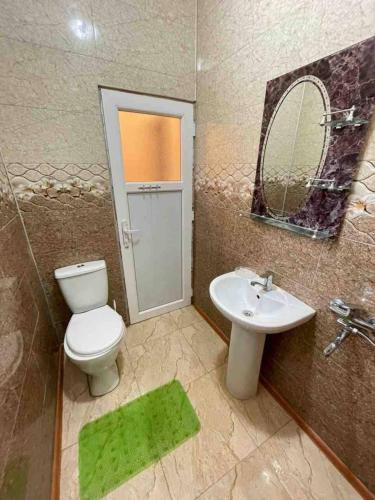 a bathroom with a toilet and a sink and a mirror at Guest House Leon in Batumi