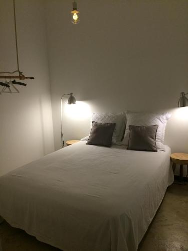 1 dormitorio con 1 cama blanca grande y 2 almohadas en Aqua Sea House, en Madalena do Mar