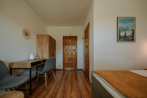 a bedroom with a desk and a bed and a table at Dom Wypoczynkowy u Staszla in Bańska Wyżna