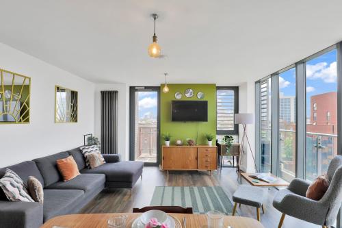 a living room with a couch and a tv at Canary Wharf Escape - Stylish 2BR - Canal Views & City Lights in London