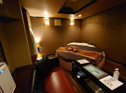 Piccola camera con letto e scrivania con scrivania. di バリタイホテルアンドリゾート狭山店 a Kurosu