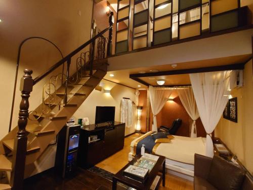 Un dormitorio con una cama elevada y una escalera en バリタイホテルアンドリゾート狭山店, en Kurosu