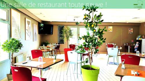 un restaurant avec des tables, des chaises et une plante dans l'établissement Campanile Marmande, à Marmande