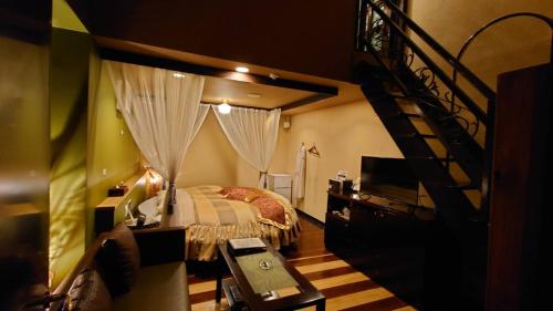 a bedroom with a bed and a spiral staircase at バリタイホテルアンドリゾート狭山店 in Kurosu