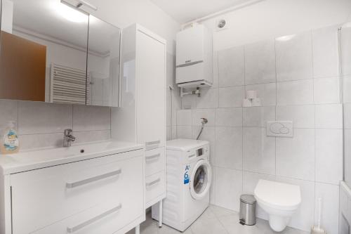 Apartment Adagio في زغرب: حمام ابيض مع غساله ومرحاض