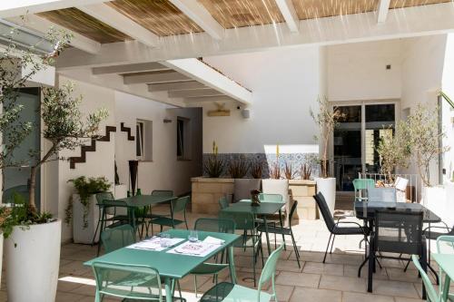 un restaurante con mesas verdes y sillas en un patio en Palazzo Cavour, en Lecce