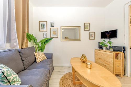 un salon avec un canapé et une table dans l'établissement Le petit Cosy, à Grenoble