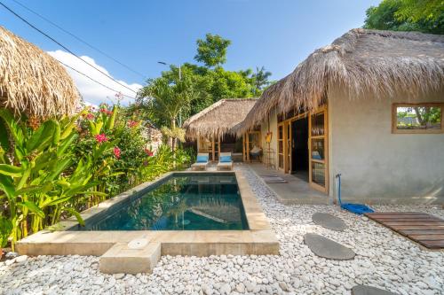 a house with a swimming pool next to a building at Villa Mandala in Gili Air