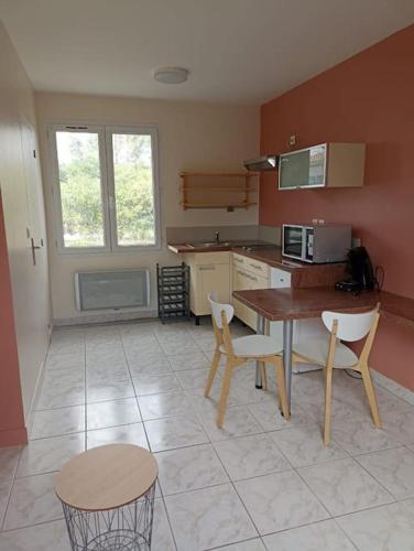 une cuisine avec une table, deux chaises et une table dans l'établissement Studio avec jardin, à Bourcefranc