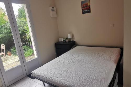 - une chambre avec un lit à côté d'une fenêtre dans l'établissement Studio avec jardin, à Bourcefranc