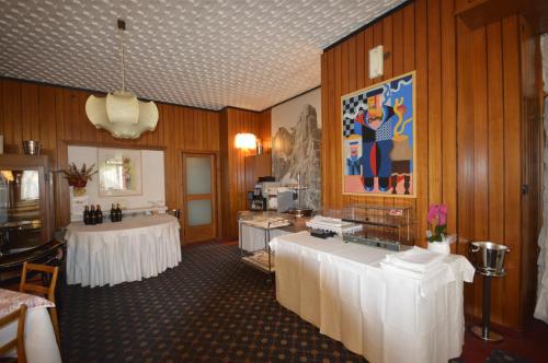 a room with two tables and a kitchen with at Villa Madonna in Madonna di Campiglio