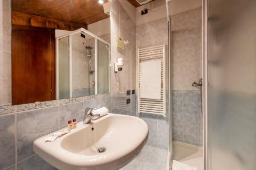 y baño con lavabo y ducha. en Alloggi Marinella, en Venecia