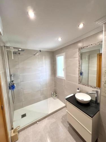 a bathroom with a shower and a sink and a tub at Apartamento junto campo de GOLF LA SELLA in Muntanya la Sella