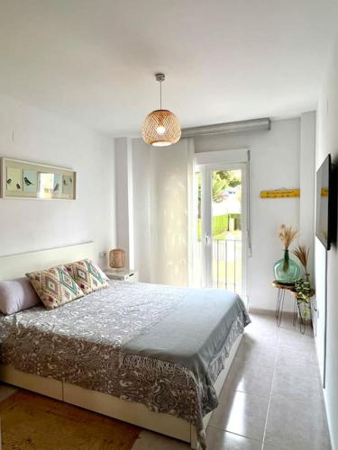 a bedroom with a bed in a white room at Apartamento junto campo de GOLF LA SELLA in Muntanya la Sella