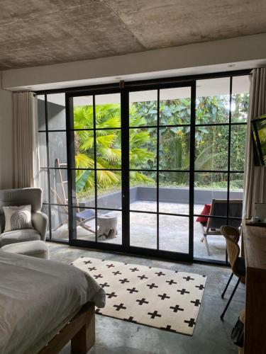a bedroom with a large window with a view of a yard at The CIVYT in Ubud