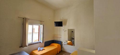 Habitación con 2 camas naranjas y ventana en San Vito Accommodations en San Vito lo Capo