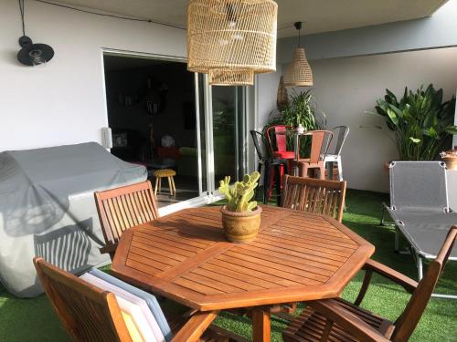 une table en bois avec des chaises et une salle à manger dans l'établissement Bel appartement au calme vue imprenable parking privé gratuit, à La Ciotat