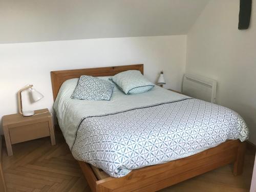 une chambre avec un lit avec deux oreillers dessus dans l'établissement La maison villeroise, à Villiers-les-Hauts