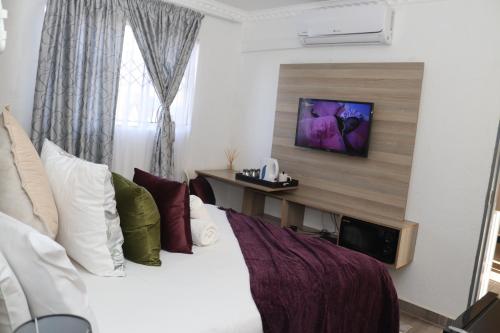 a bedroom with a bed and a tv on a wall at Lesiba guesthouse in Kwamhlanga