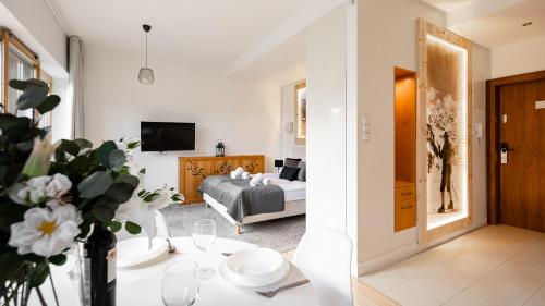 a living room with a bed and a table with flowers at Aparthotel Delta Boutique in Kościelisko