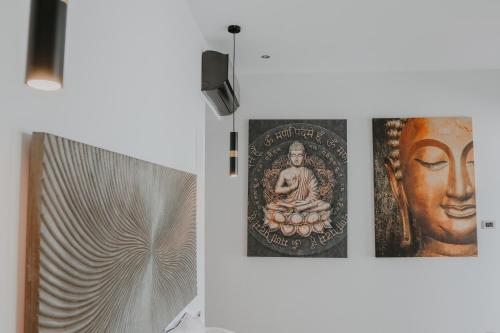 two posters of a buddha on a wall next to a door at BLACK AMBER BOUTIQUE HOTEL in Lampi
