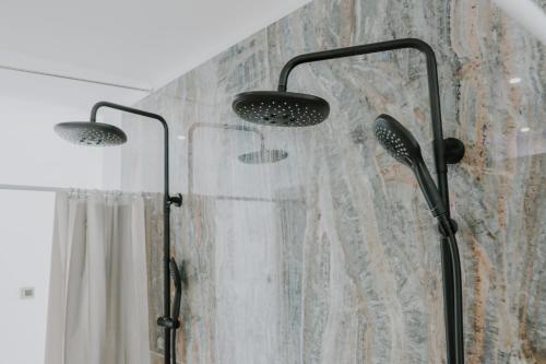 a shower with two lights and a shower curtain at BLACK AMBER BOUTIQUE HOTEL in Lampi