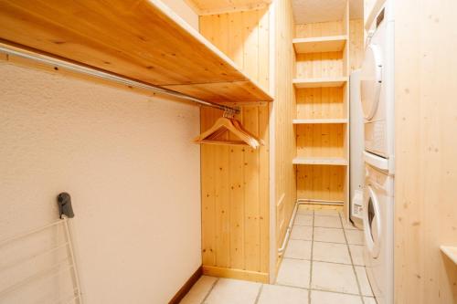 a small kitchen with a refrigerator and a door at Le Col Panoramic in La Toussuire