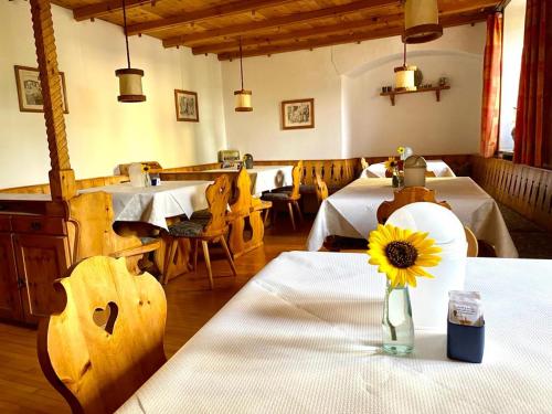 ein Restaurant mit Tischen und eine Vase mit Sonnenblume in der Unterkunft Garni Sonne in Mals im Vinschgau