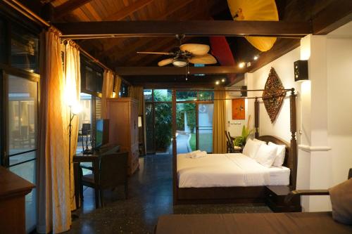 a bedroom with a bed and a ceiling fan at Villa Emerald Sand - Beach Front 4 Bed Pool Villa in Koh Samui 