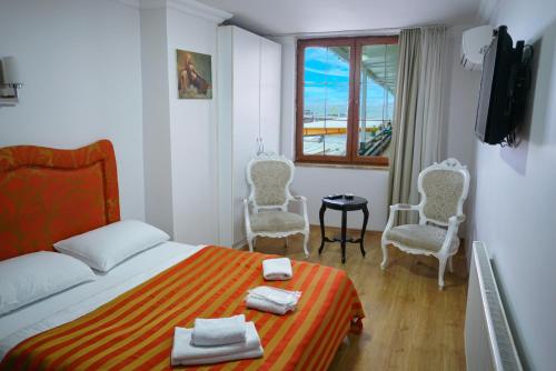 um quarto com uma cama, 2 cadeiras e uma janela em My Way Tera Butik Otel em Adalar