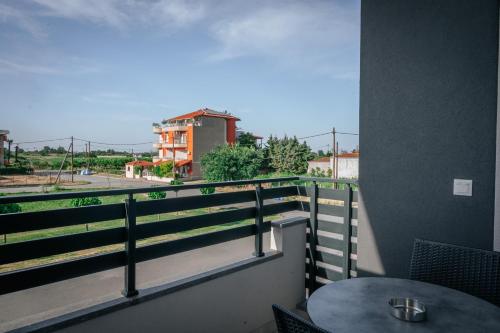 a balcony with a table and a view of a street at Elizabeth Queen Luxury Rooms in Paralia Katerinis