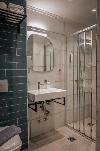 a bathroom with a sink and a shower at Elizabeth Queen Luxury Rooms in Paralia Katerinis