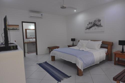 a bedroom with a bed and a mirror and a television at Pousada Caminho da Praia in Jericoacoara