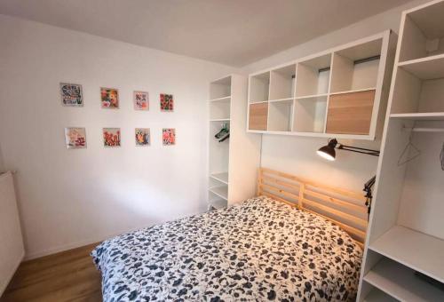 a bedroom with a bed in a white room at Konk-Kerne, magnifique T2 proche tramway in Nantes