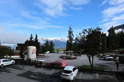 - un parking avec des voitures garées devant une montagne dans l'établissement Residence Le 1650 - Studio pour 4 personnes cœur de station les orres 1650 MAE-8111, aux Orres